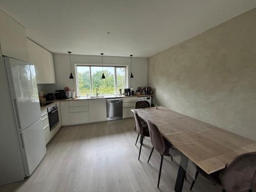 cocina con mesa de madera y ventana grande en Bright, well furnished apartment, en Hillerød