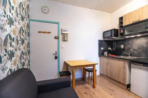 a small kitchen with a table and a counter at L'Entre Nous en Chartreuse in Saint-Pierre-de-Chartreuse