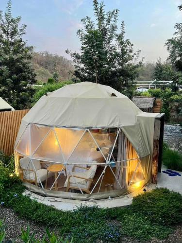 a tent with chairs inside of it in a yard at The X10 Nordic Tent and Glamping Pool Villa Khaoyai เขาใหญ่ - SHA Certified in Ban Thung Sawang