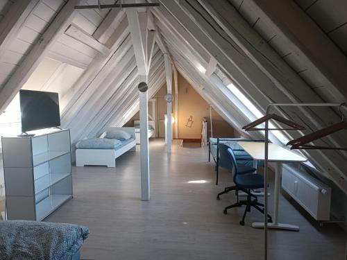 a attic room with a bed and a desk and chairs at Monteurwohnung - Bertholdstraße 19 in Pforzheim