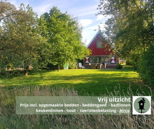 a red house with a sign in front of it at Huisje Weidezicht in Lievelde