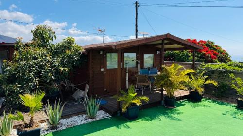 a small house with a deck and some plants at Finca Maradentro - private pool and jacuzzi with ocean view in Arafo