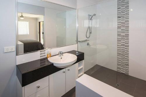 a bathroom with a sink and a glass shower at Haven By the Bay- Short walk to Broadwater beach in Broadwater