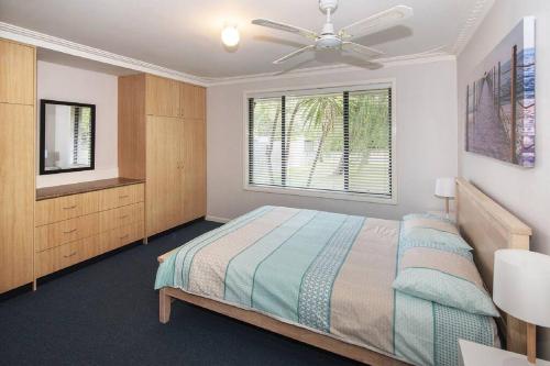 a bedroom with a bed and a ceiling fan at Haven By the Bay- Short walk to Broadwater beach in Broadwater