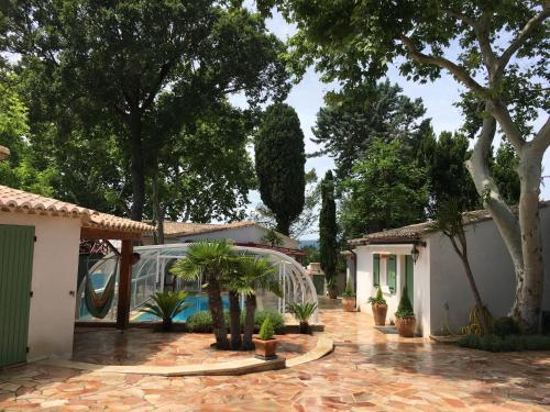 une maison avec un jardin arboré et une piscine dans l'établissement Villa de charme très grand confort à pied du centre historique d'Uzés, à Uzès