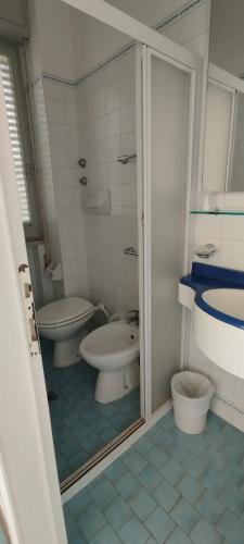 a bathroom with two toilets and a glass shower door at Hotel Acerboli in Rimini