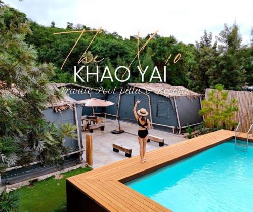 a woman standing on a deck next to a swimming pool at The X10 Nordic Tent and Glamping Pool Villa Khaoyai เขาใหญ่ - SHA Certified in Ban Thung Sawang