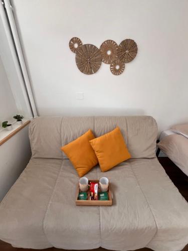 a couch with two pillows and a tray on it at Hypercentre Béthune - 4 pers - Parking privé in Béthune