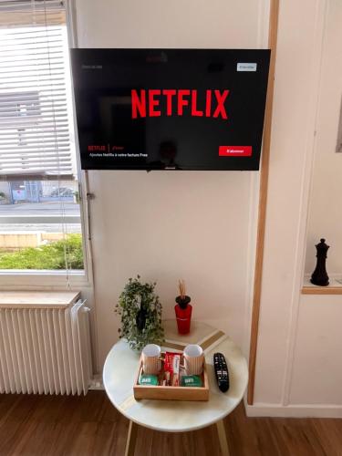 a netflix sign on a wall above a table at Hypercentre Béthune - 4 pers - Parking privé in Béthune