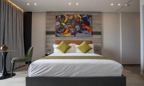 a bedroom with a bed and a painting on the wall at Beverly Beach Hotel in Jounieh