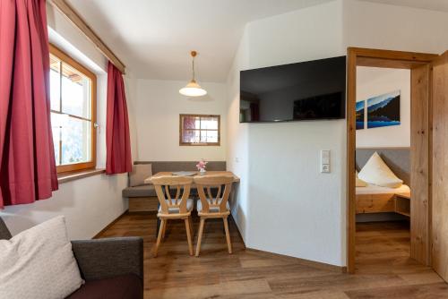 a living room with a table and a bedroom at Pension Bergbauernhof Irxner in Schladming