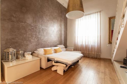 a room with a bed and a couch and a window at Gold Apartment Viareggio in Viareggio