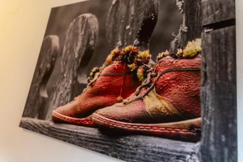 a picture of a pair of red shoes on a wall at Pension Bergbauernhof Irxner in Schladming