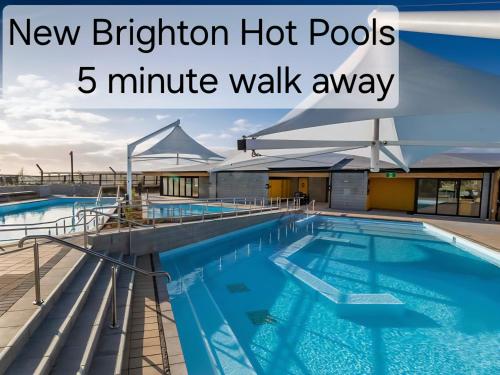 Una piscina en la parte superior de un edificio con las palabras "New Brighton Hot Pools" en Beachside Townhouse, en Christchurch