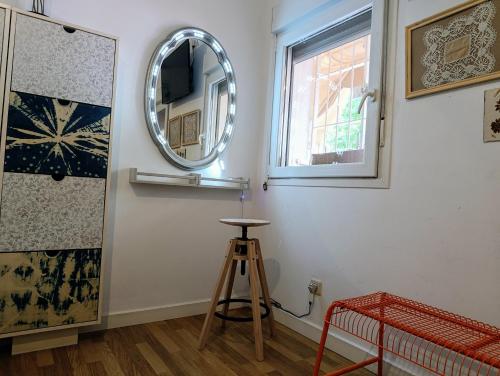 a mirror on a wall next to a stool in a room at Women Only - Solo Mujeres in Seville