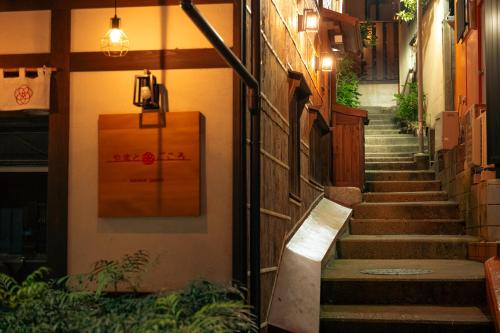 an alley with stairs and a suitcase on the wall at Koyado Surugatei in Kobe