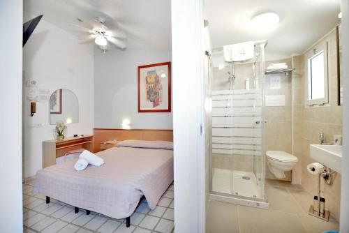 a bedroom with a bed and a bathroom with a shower at Hotel Itta in Caorle