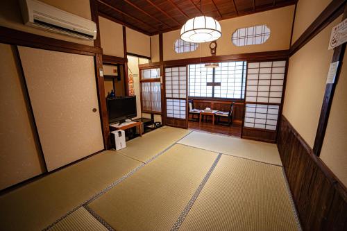 a room with a room with a door and a television at Private Onsen 泊 - Park - Tsuetate in Oguni