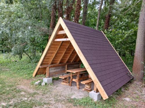 a small house with a roof on top of it at Hídláb Apartman in Kimle