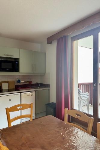 Il dispose d'un balcon et d'une cuisine avec une table et des chaises. dans l'établissement Puy St Vincent 1800 - appt 6 pers - près des pistes, à Puy-Saint-Vincent