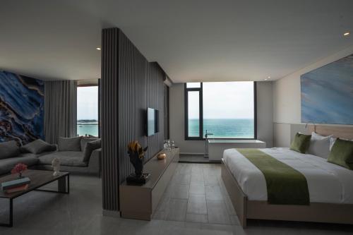 a bedroom with a large bed and a living room at Beverly Beach Hotel in Jounieh
