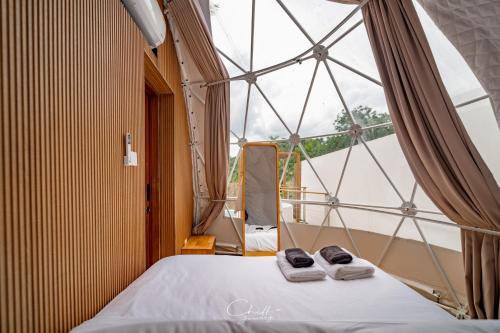 une chambre avec un lit et une grande fenêtre dans l'établissement The X10 Nordic Tent and Glamping Pool Villa Khaoyai เขาใหญ่ - SHA Certified, à Ban Thung Sawang