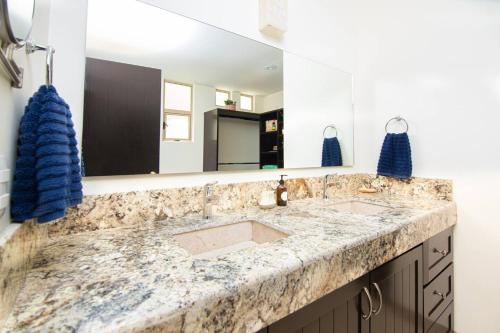 a bathroom with a sink and a large mirror at Vista Del Arco in Cabo San Lucas