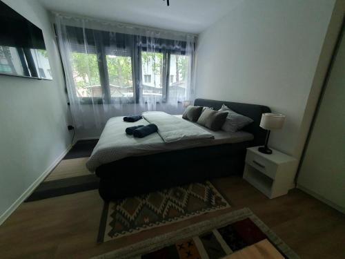 a small bedroom with a bed and a window at Sofia Apartment free parking in Sarajevo