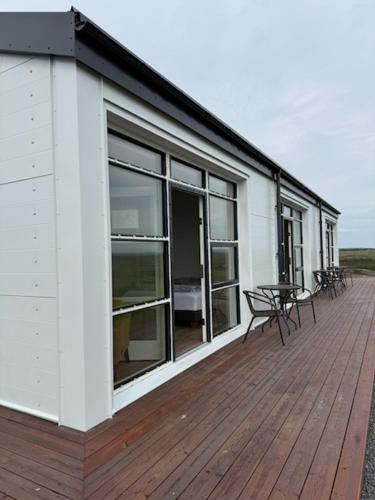 a building with a deck with a table and chairs at Holssel road 864 in Myvatn