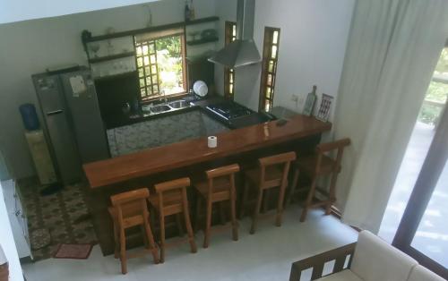 a kitchen with a table and some stools at Puerto Galera Hilltop Guesthouse -Tropical Retreat in Puerto Galera