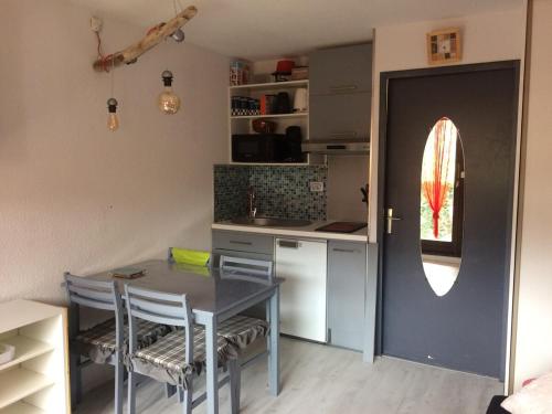 une cuisine avec une table et une table ainsi qu'une porte dans l'établissement Studio Hyper centre - Ski, à Villard-de-Lans