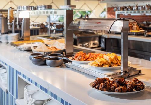 a buffet line with plates of food and other foods at King Solomon Hotel Tiberias in Tiberias