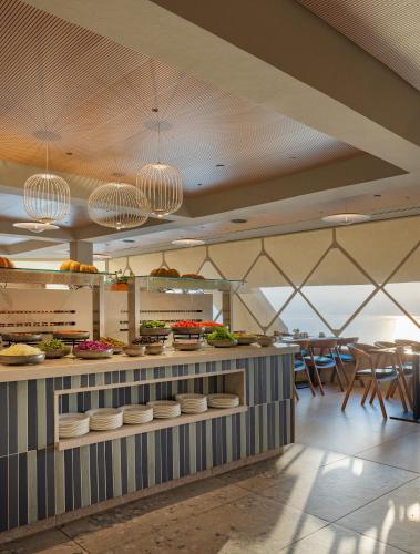 a restaurant with a counter with food on it at King Solomon Hotel Tiberias in Tiberias