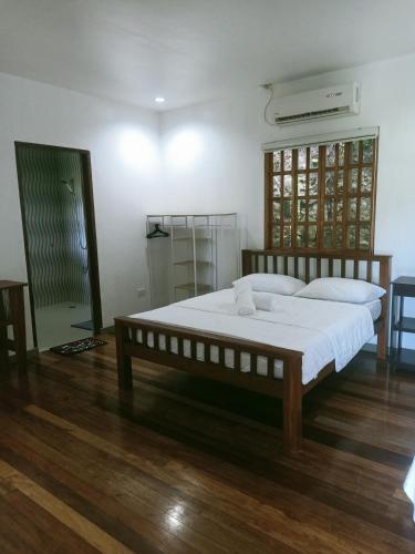 a bedroom with a large bed with white sheets at Puerto Galera Hilltop Guesthouse -Tropical Retreat in Puerto Galera