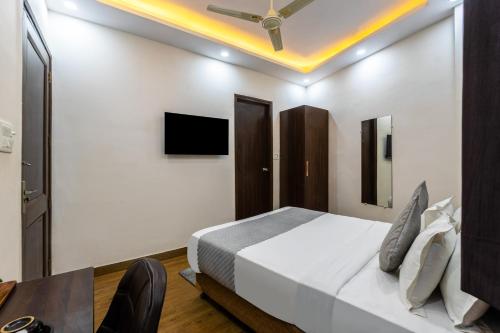 a bedroom with a bed and a table and a tv at Hotel Mannat Green Near Naraina Vihar Metro Station in New Delhi