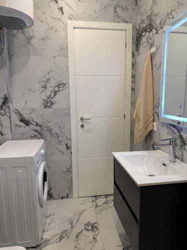 a bathroom with a sink and a toilet and a mirror at DG Apartment in Golem