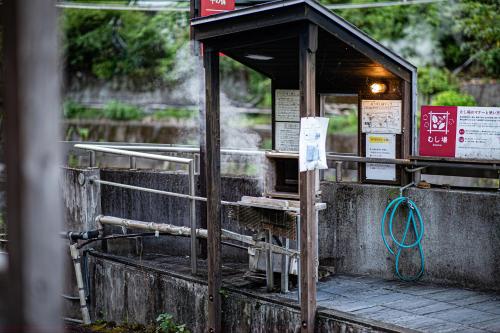 a phone booth with a sign on it at Private Onsen 泊 - Park - Tsuetate in Oguni