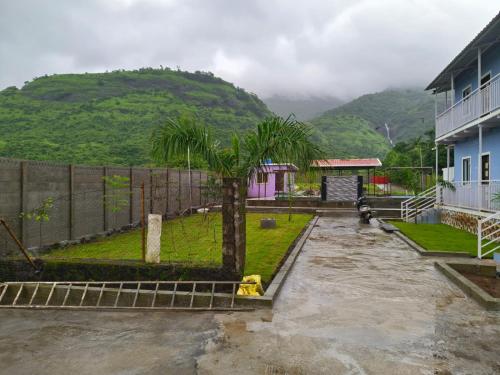 a house with a palm tree in a yard at Happy Hills Karjat in Karjat