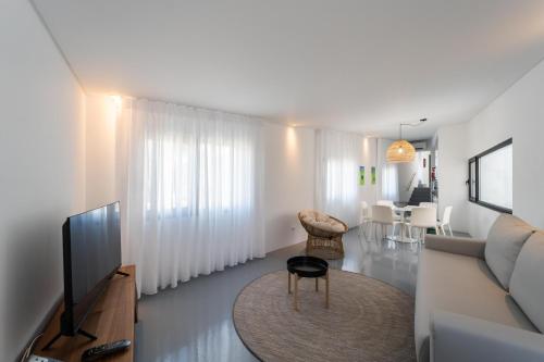 a living room with a couch and a television at Oceanside Village 4 in Lagoa