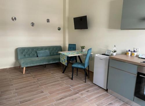 a living room with a table and a couch and a kitchen at La Rosa Verde in Castrovillari