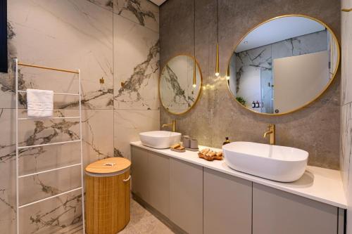 a bathroom with two sinks and a mirror at אחוזת דוד - וילה יוקרתית עם בריכה פרטית in Hatzor haglilit