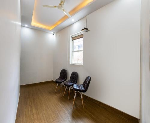a group of chairs in a room with a window at Hotel Mannat Green Near Naraina Vihar Metro Station in New Delhi