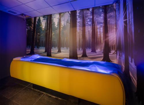 a room with a large painting of a forest at Alchimia WellResort in Comano Terme