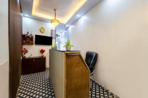 a hallway with a desk and a tv in a room at Hotel Mannat Green Near Naraina Vihar Metro Station in New Delhi