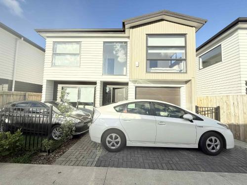 a white car parked in front of a house at Reeves awesome stay in Auckland