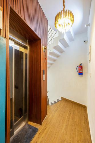 a hallway with a chandelier and a hard wood floor at Hotel Mannat Green Near Naraina Vihar Metro Station in New Delhi