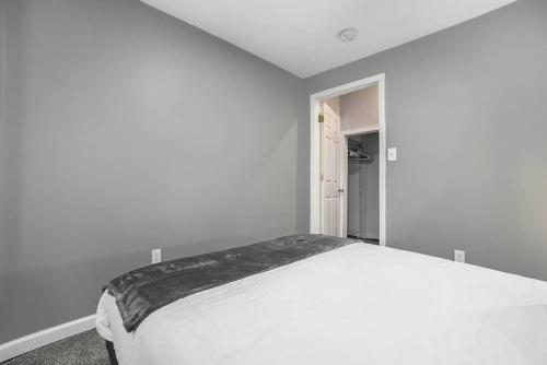 a white bedroom with a large white bed in it at The Downtown Delight - New Corporate Apt Downtown in Grand Rapids