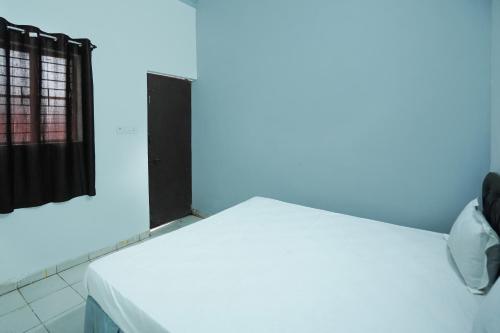 a room with a white bed with a blue light at Hotel O Shining Star in Bhilai