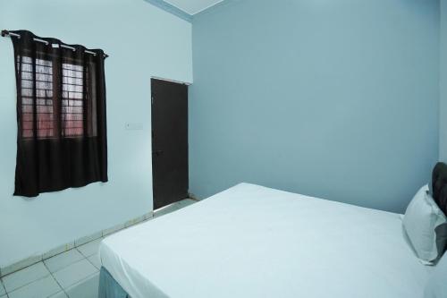 a room with a white bed with a blue light at Hotel O Shining Star in Bhilai