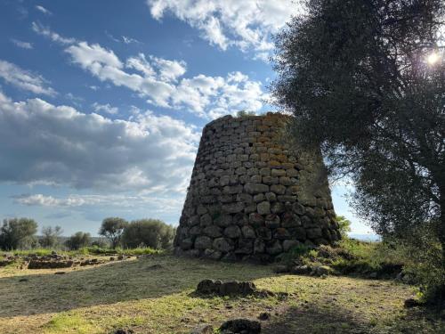 an old stone building sitting on top of a field at B&B San Leonardo Dualchi in Dualchi